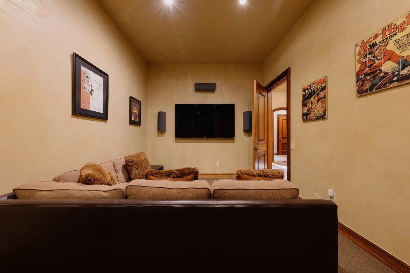 Una sala de estar con un televisor montado en la pared sobre los asientos.
