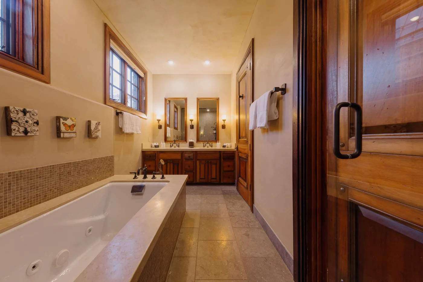 Un baño con una bañera junto a la pared y un tocador al fondo.