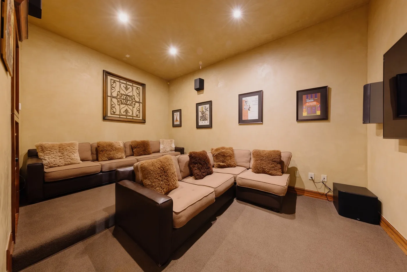 A living room with sectional seating and framed artwork on the walls.
