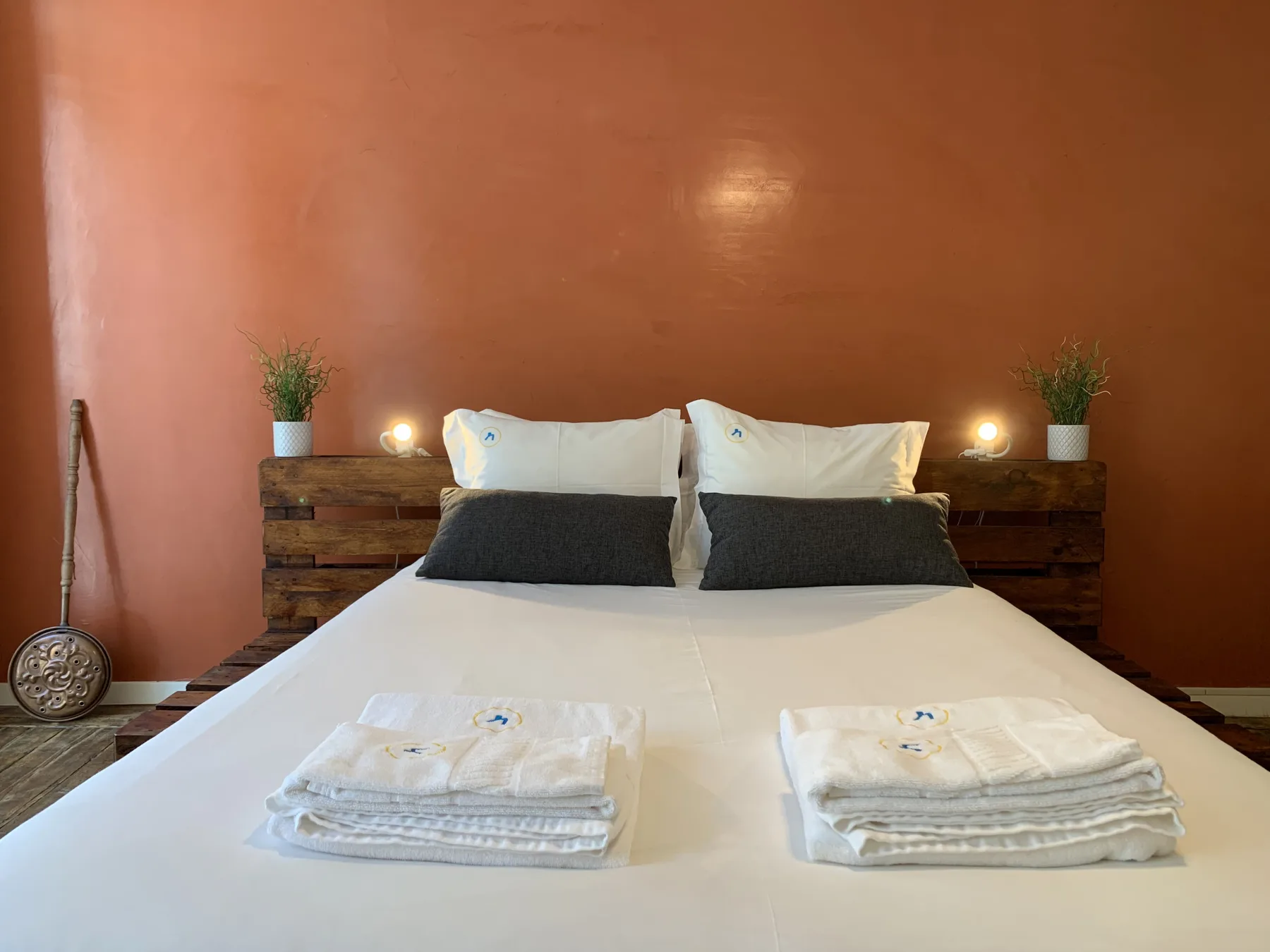 Un dormitorio con una cama bien hecha y toallas dobladas.