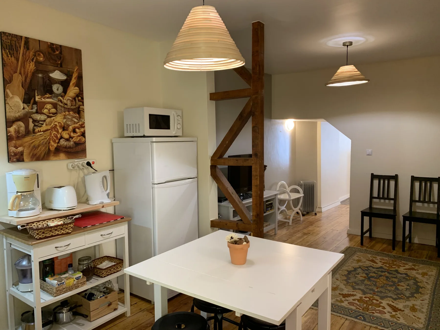 Comedor con una mesa blanca junto a una cocina compacta.