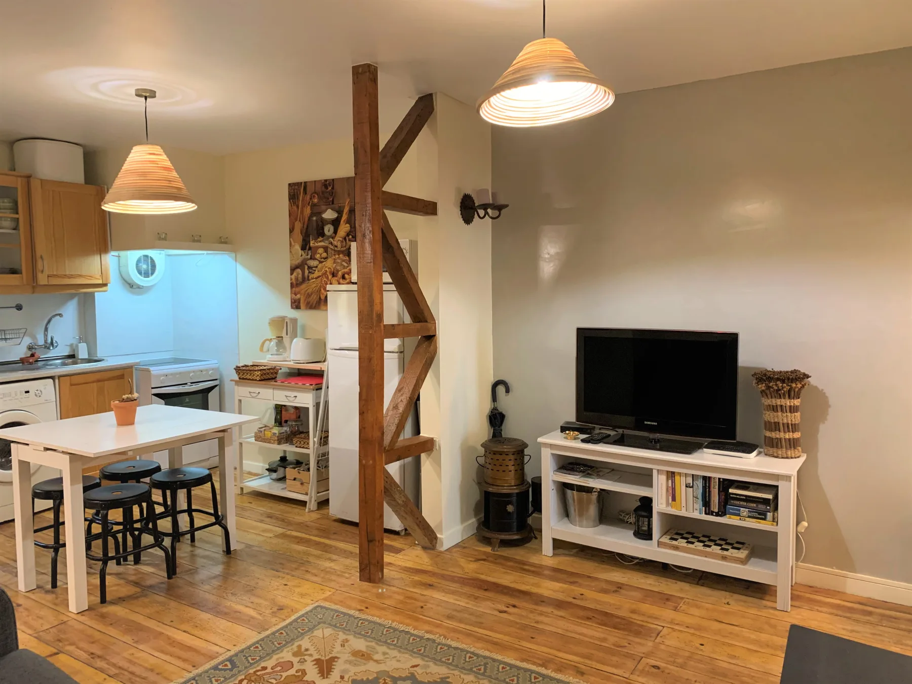 Una sala de estar y comedor diáfana con un televisor y una cocina.
