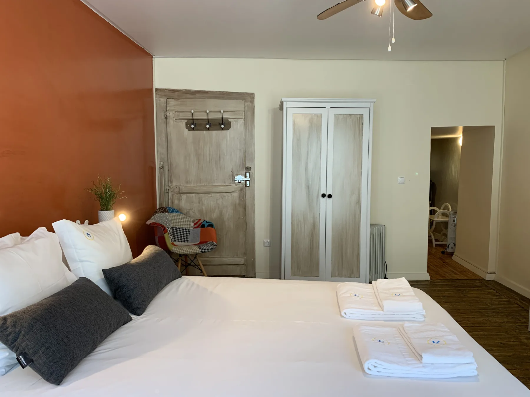 Dormitorio con una cama, un armario y una puerta de madera.