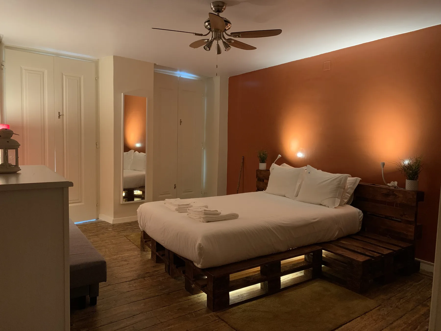 Un dormitorio con una cama, mesitas de noche y un ventilador de techo.