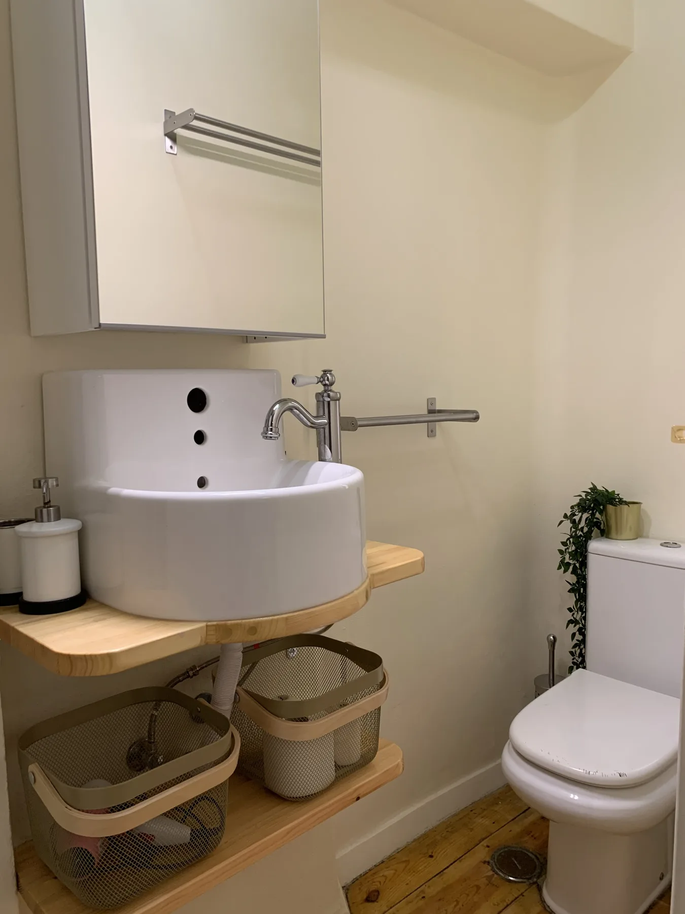 Un baño compacto con lavabo suspendido e inodoro.