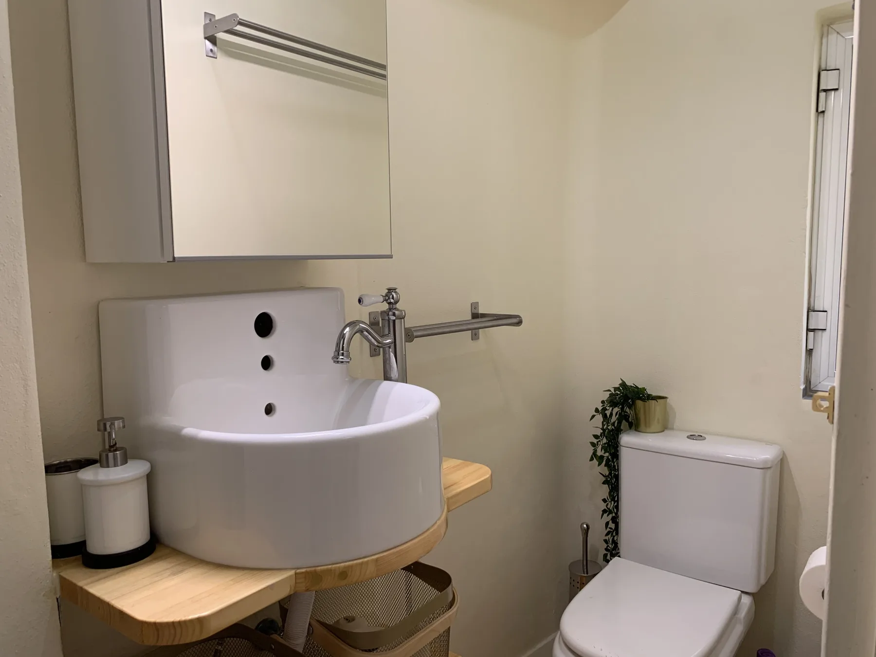 Un baño con lavabo sobre encimera, espejo e inodoro.