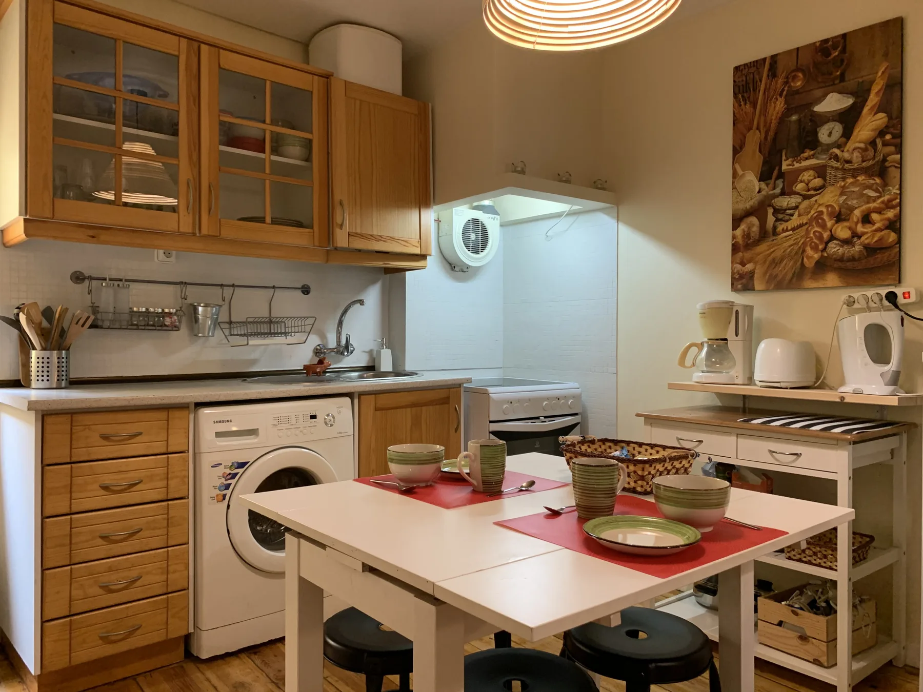 Una cocina y comedor con armarios de madera y una mesa preparada para comer.