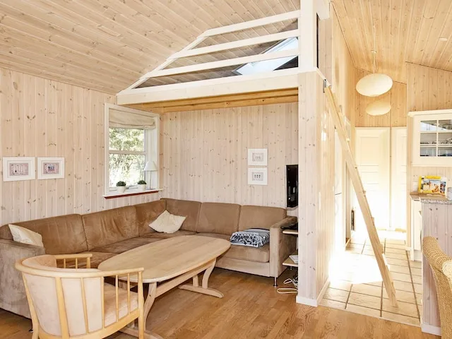 Una sala luminosa con asientos en esquina y una mesa de centro de madera.