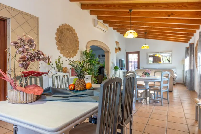 Un comedor con mesas y sillas bajo vigas de madera expuestas.
