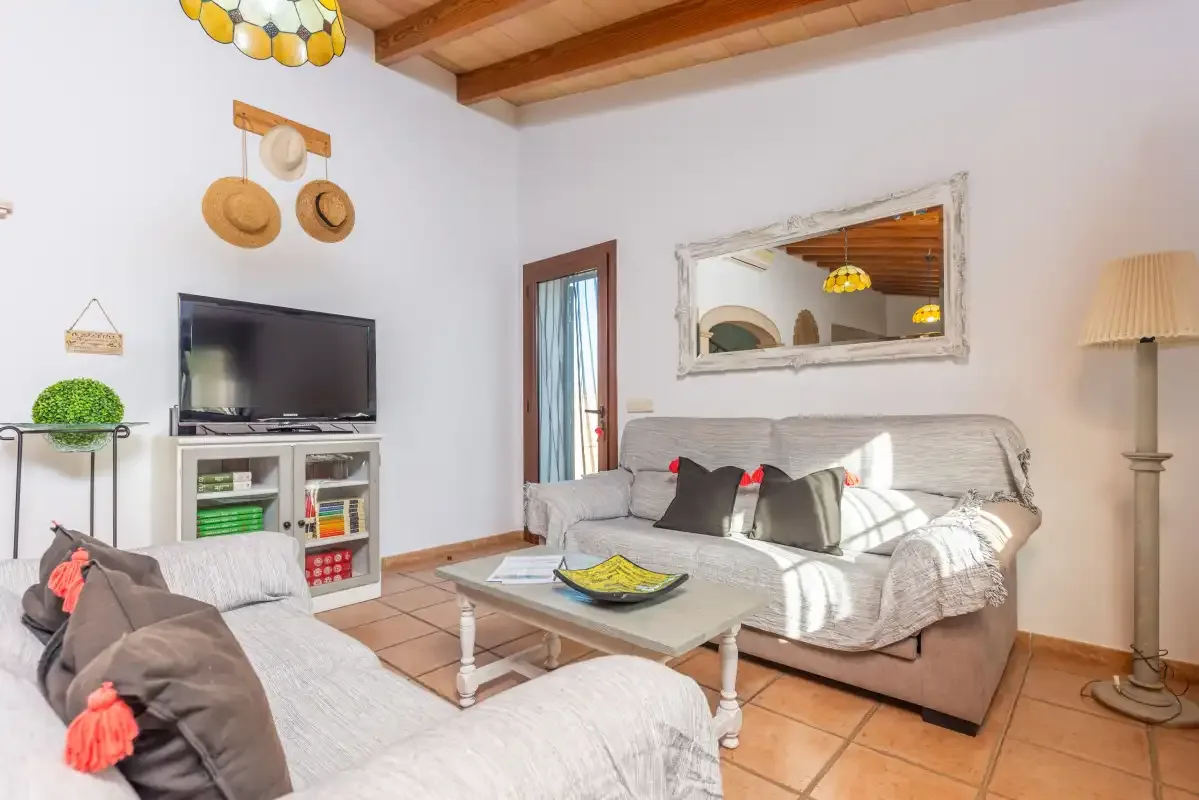 Sala de estar con asientos, un televisor y una mesa de centro baja.