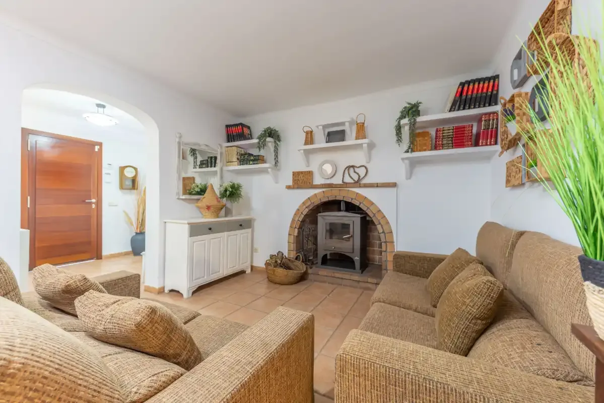 Una sala de estar con asientos dispuestos alrededor de una chimenea de ladrillo.