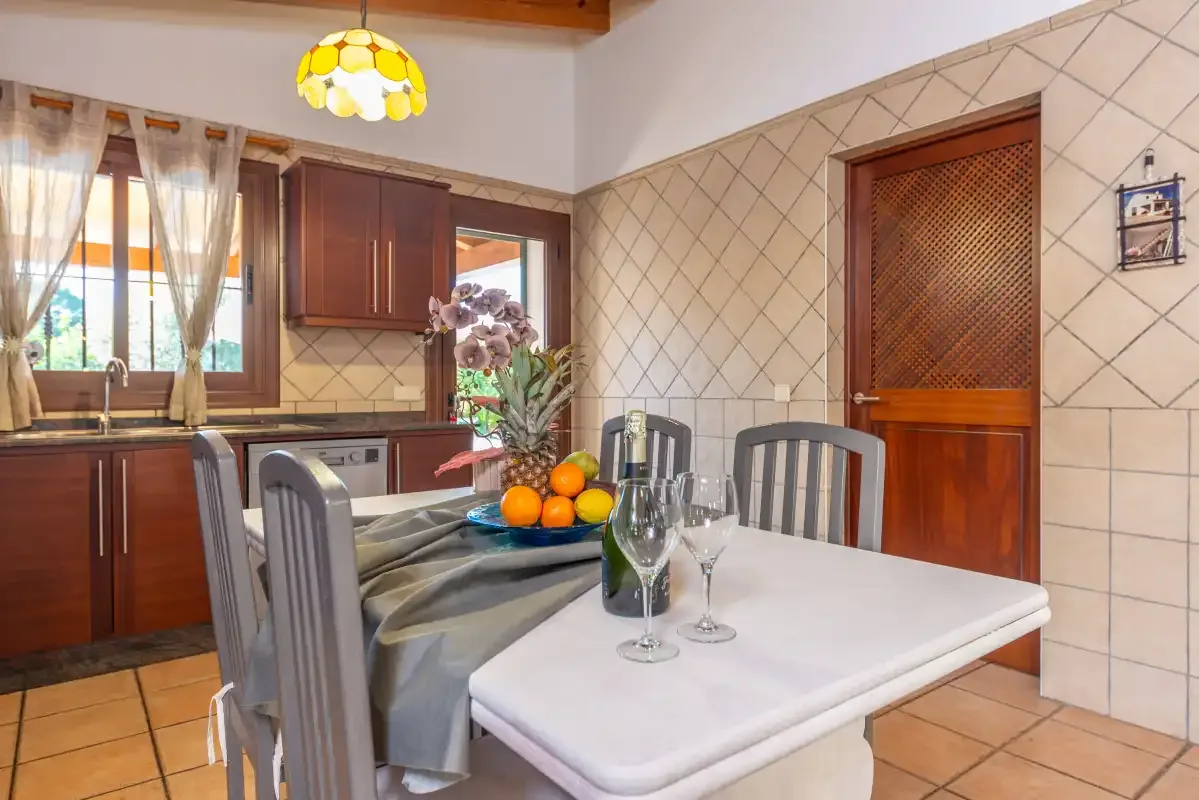 Una cocina y zona de comedor con una mesa junto a la encimera.