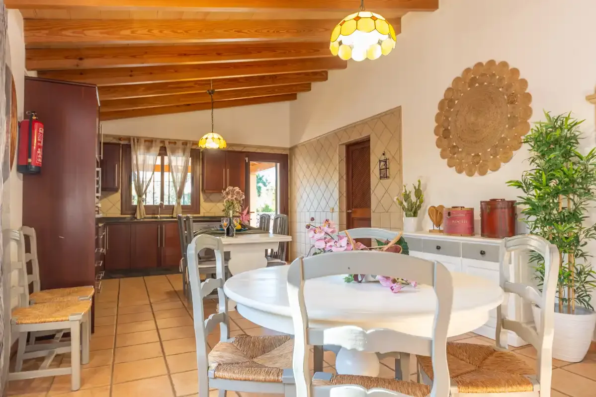 Comedor con una mesa redonda y una cocina al fondo.