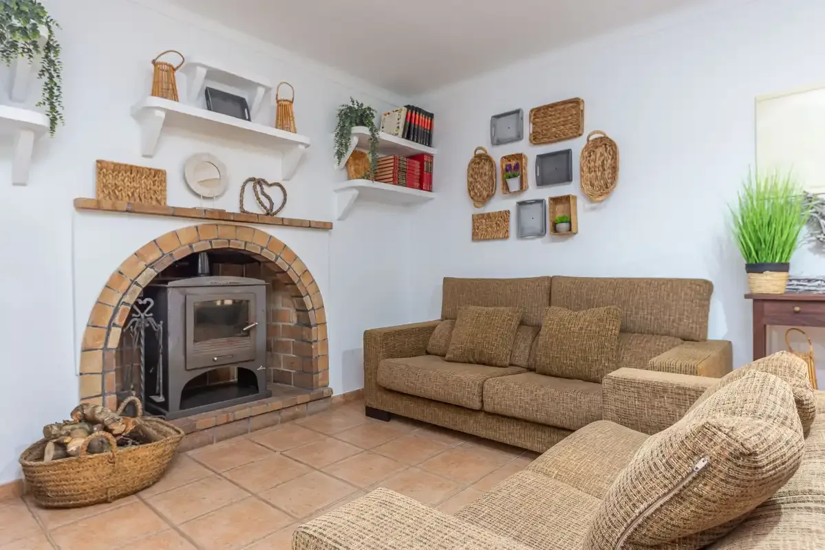 Una sala de estar con chimenea de ladrillo y asientos de fibras tejidas.