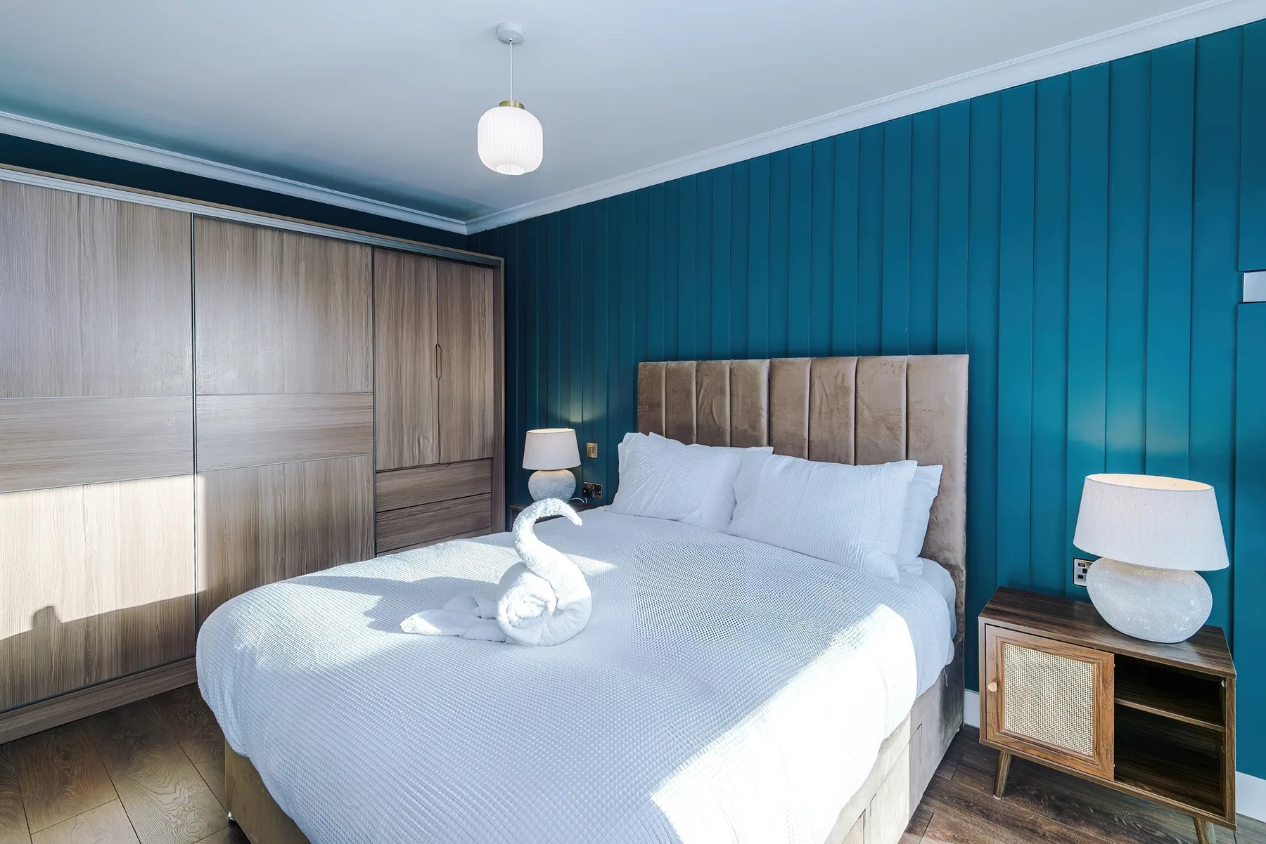 Un dormitorio con una cama bien tendida y armarios empotrados.