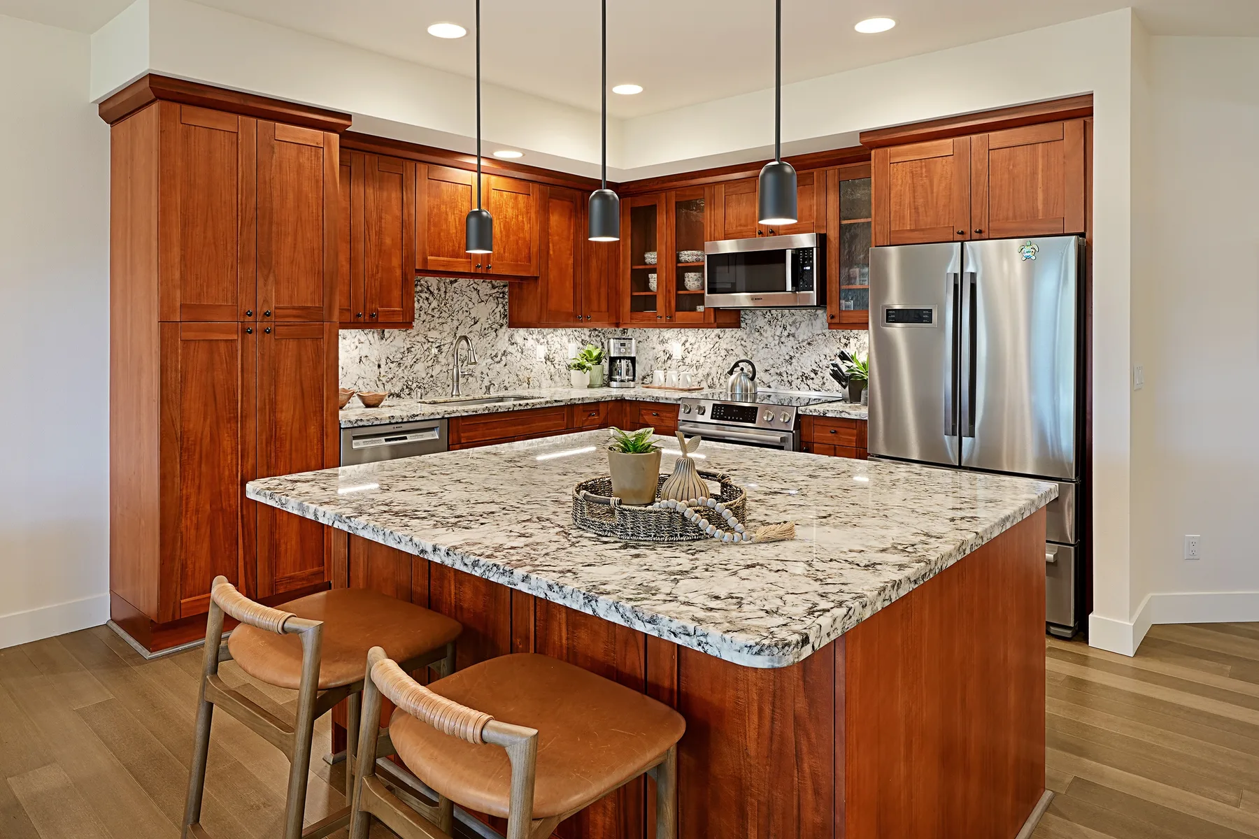 Una cocina con gabinetes de madera, una isla grande y electrodomésticos de acero inoxidable.