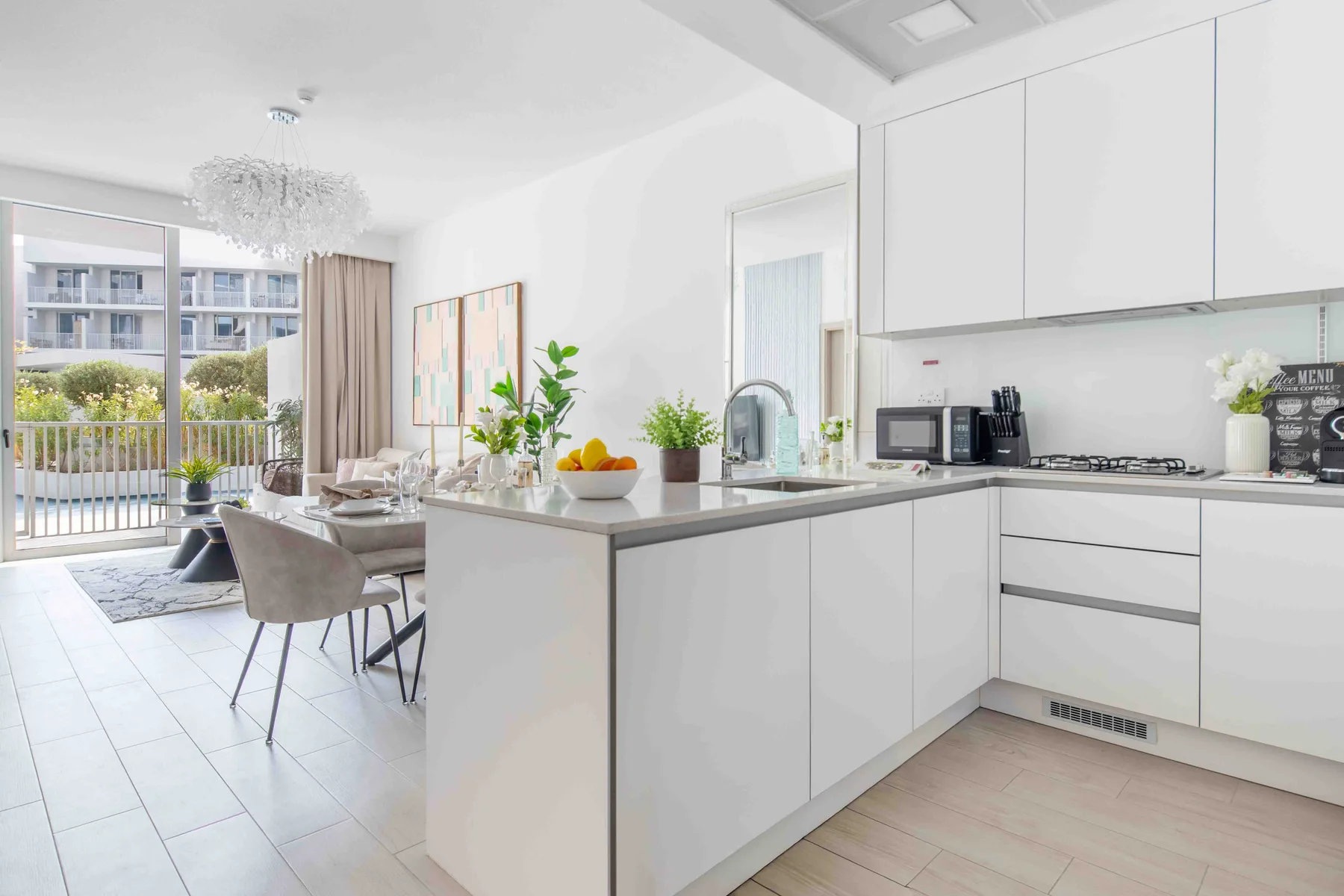 A bright open-plan kitchen and dining area with a countertop and large windows.