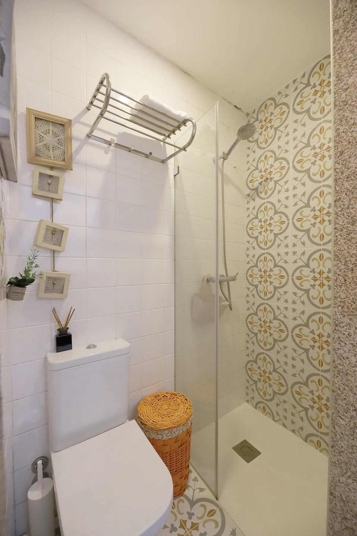 Bathroom with a shower, patterned tile, and a toilet.