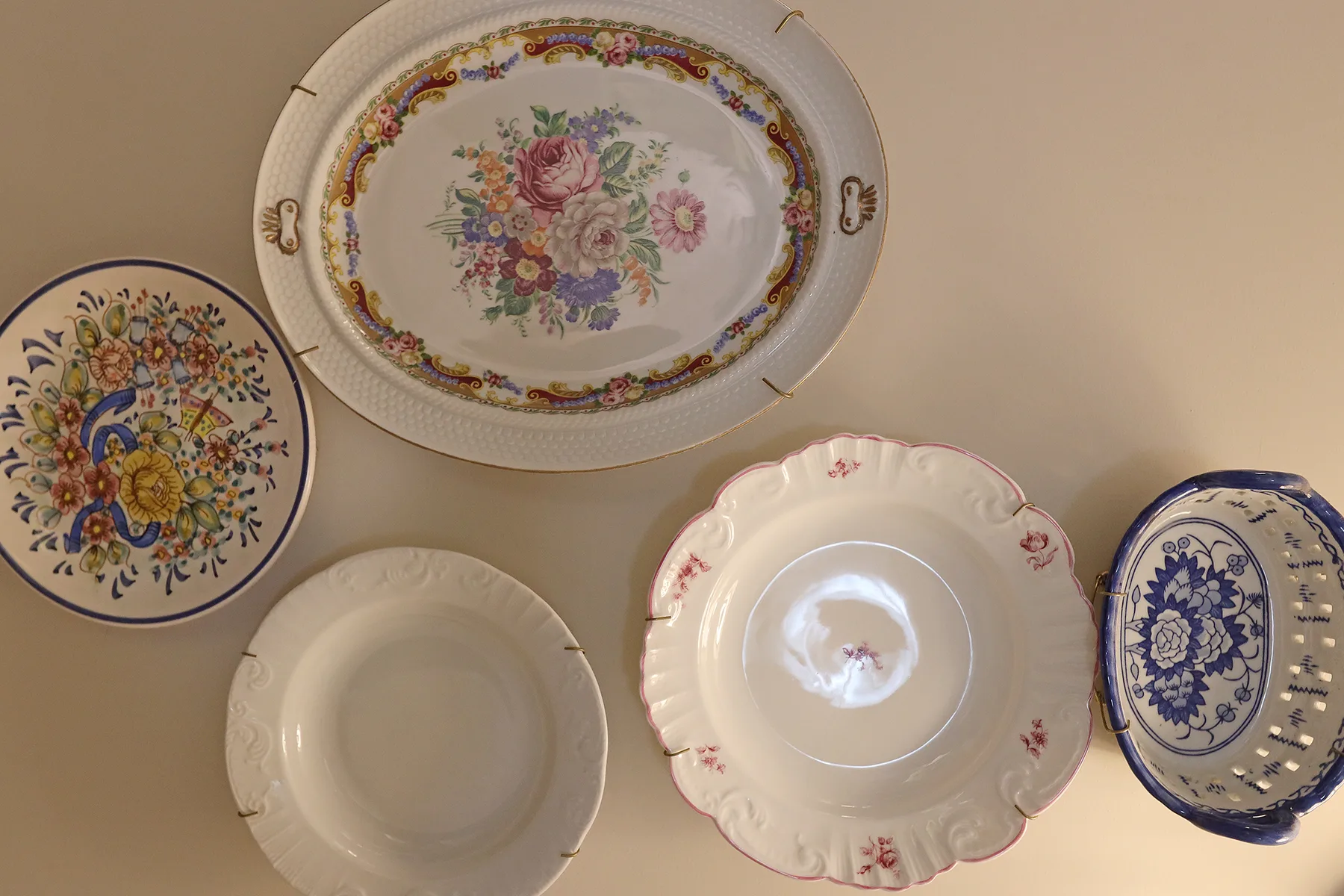 Decorative plates with colorful floral patterns are displayed on a wall.