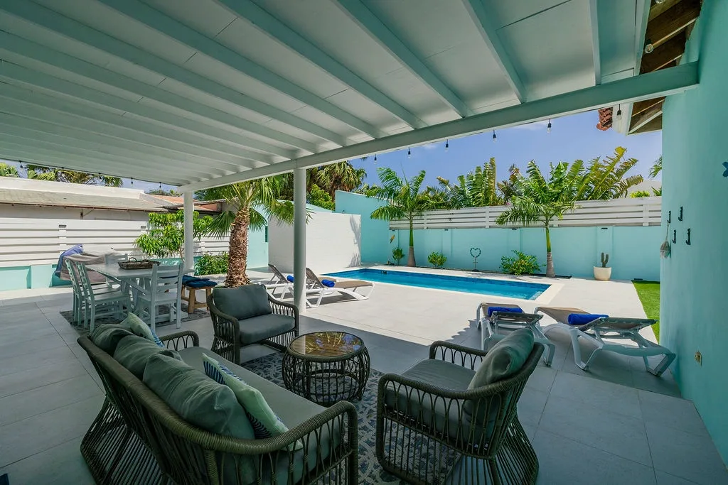 Step into your private oasis where a sleek pool awaits, framed by swaying palms and sunny skies. Relax on plush lounge seating under a cool covered patio, or dine al fresco just steps from the water.