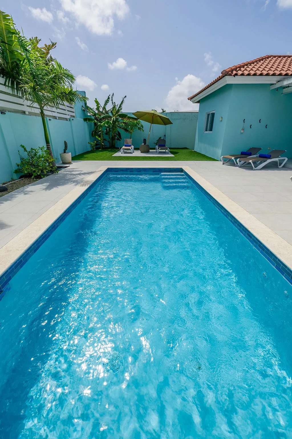 Your private oasis awaits: dive into crystal-clear waters, lounge under swaying palms, and soak up the tropical sun in your secluded backyard sanctuary.