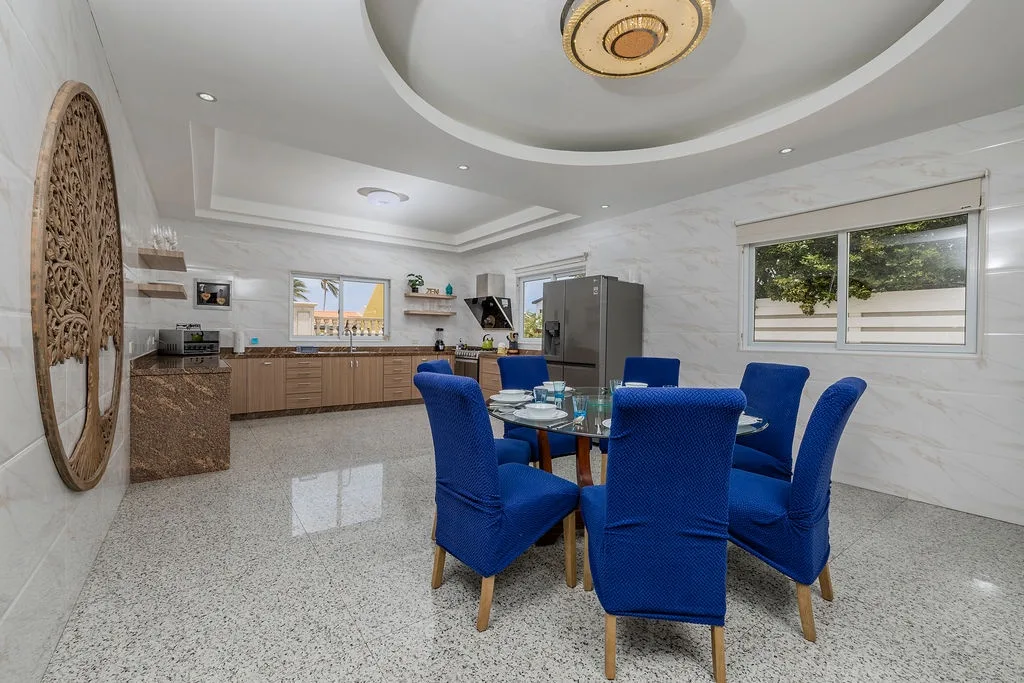 Gather around the elegant dining table where vibrant blue chairs invite you to share meals and make memories in this bright, airy space with a fully equipped modern kitchen at your fingertips.