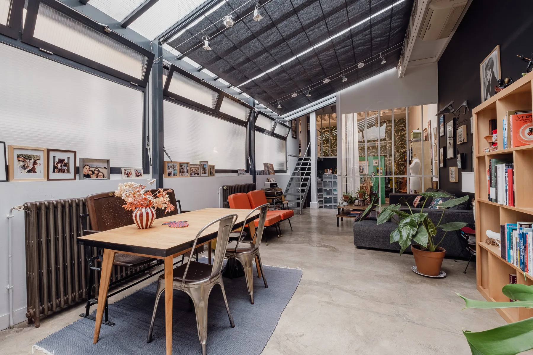 A spacious interior combines a dining area with a lounge and leafy plants.