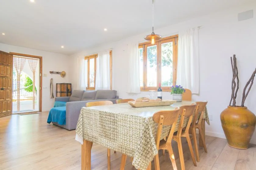 A dining area with a table and chairs beside a bright living space.