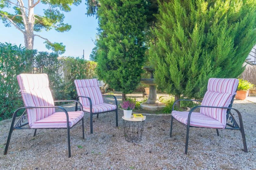 An outdoor seating area with striped cushioned chairs arranged around a small table.