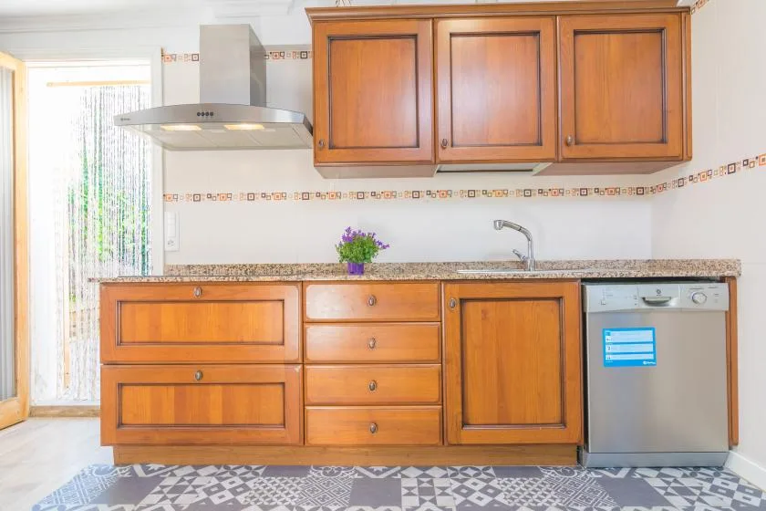 A kitchen with wooden cabinets, a countertop, and a sink.