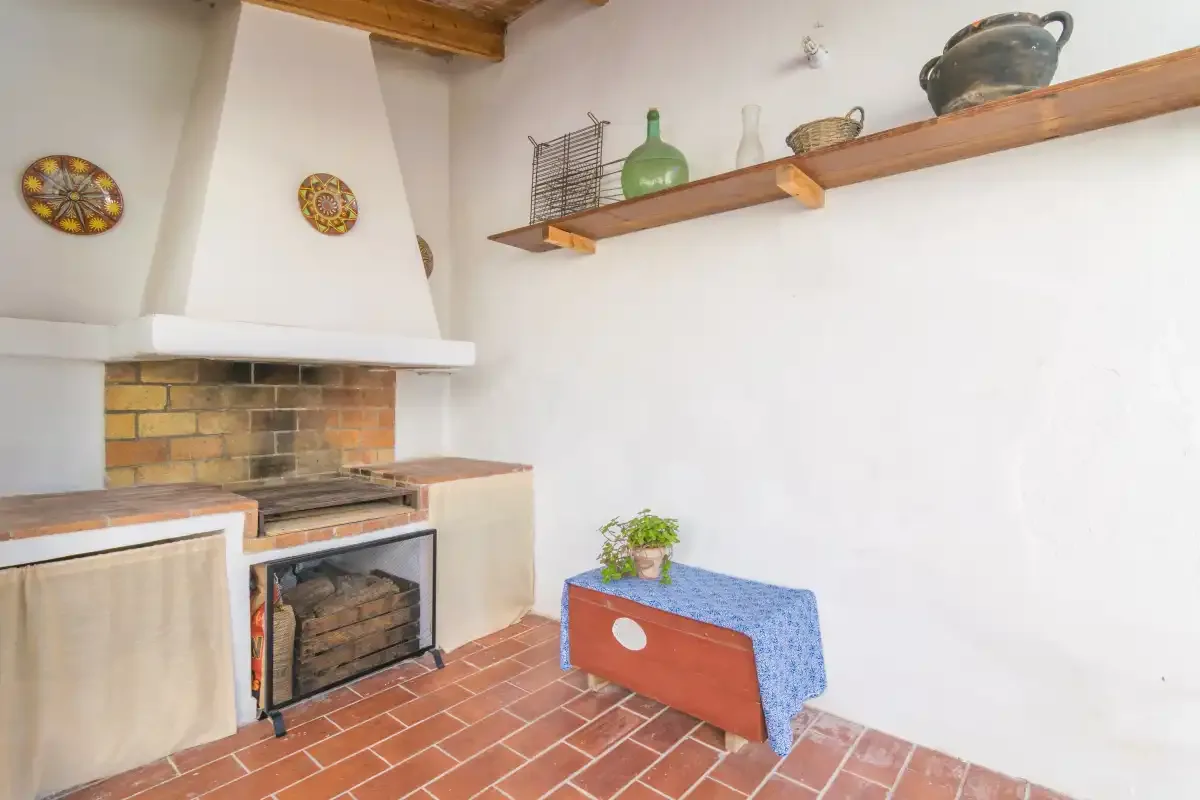A rustic indoor fireplace and hearth sit beside a small table.