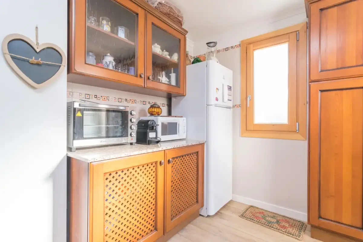 A compact kitchen with wooden cabinets and countertop appliances.