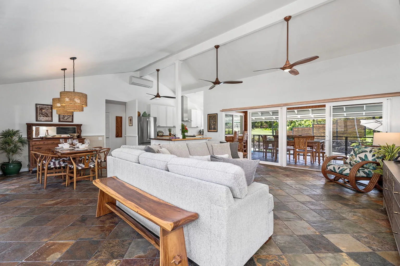A spacious living and dining area opens onto a patio through wide glass doors.