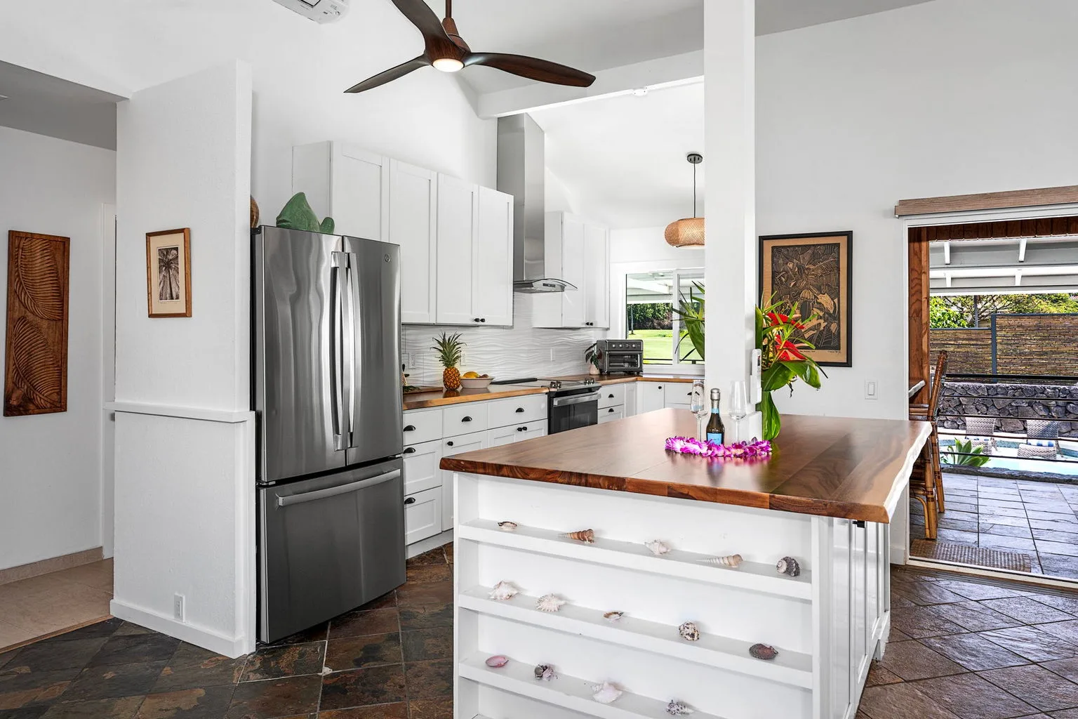 A bright kitchen with white cabinets, stainless steel appliances, and a central island.