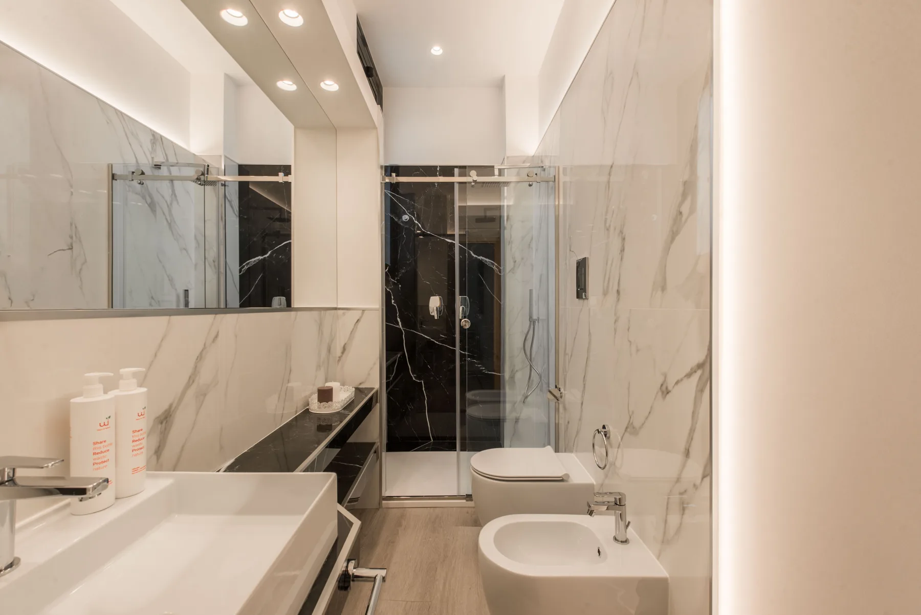 A modern bathroom with a sink, toilet, and glass shower.