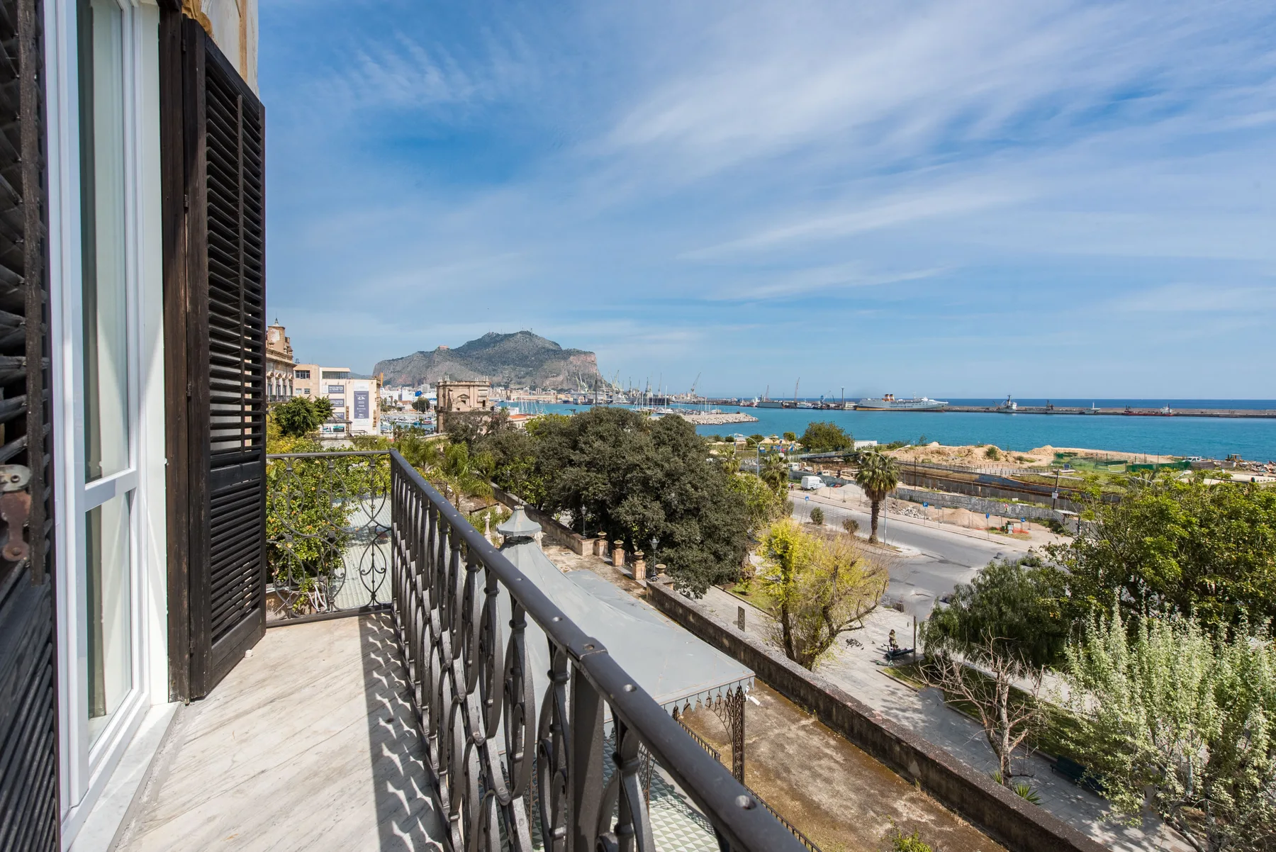 A balcony overlooks a coastal town and the sea.
