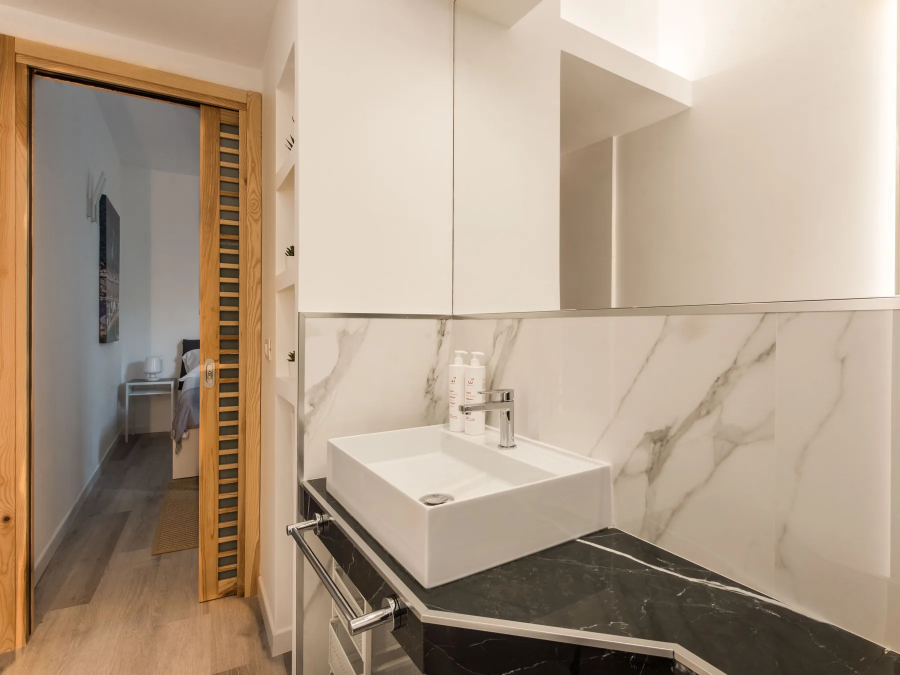 A bathroom vanity with a rectangular sink and large mirror.