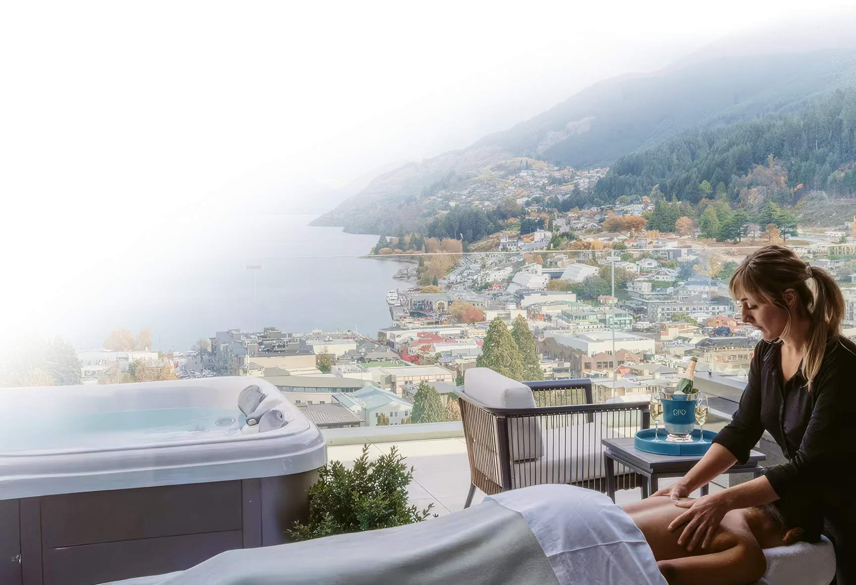 In-suite wellness treatment on a balcony overlooking a town, lake, and mountains.
