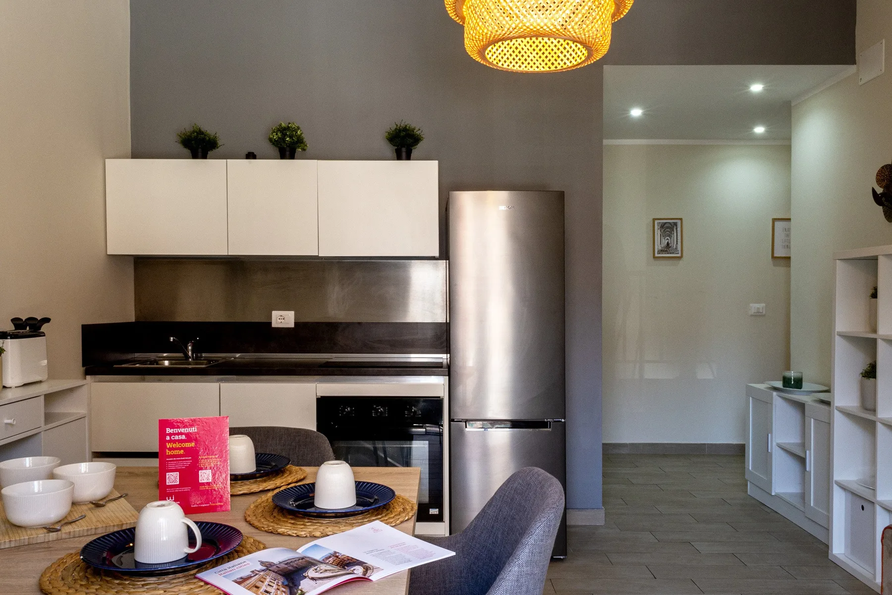 A modern kitchen with a dining table and an open doorway to the adjoining space.
