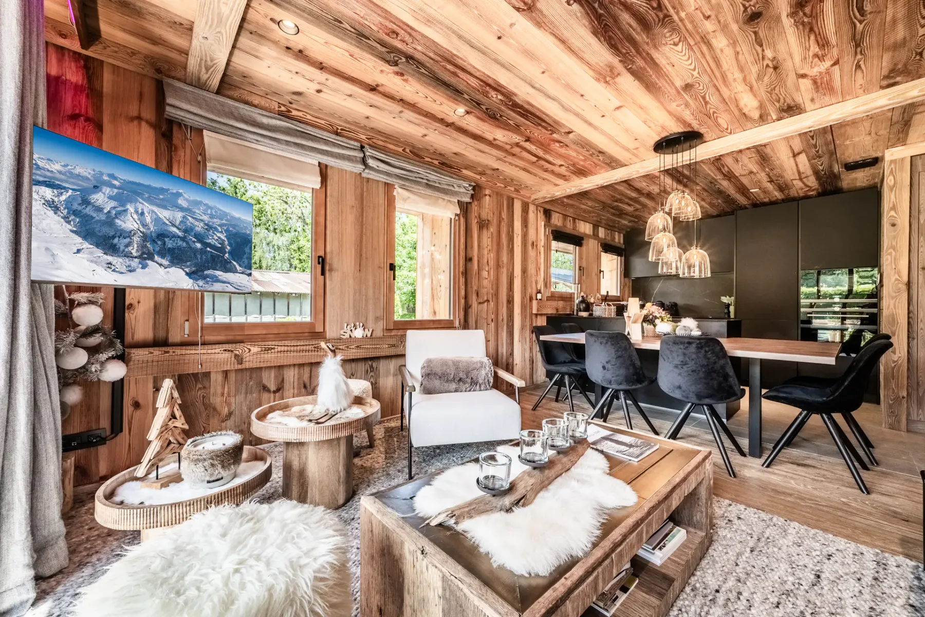 Una sala revestida de madera combina una zona de estar con una mesa de comedor y sillas oscuras.
