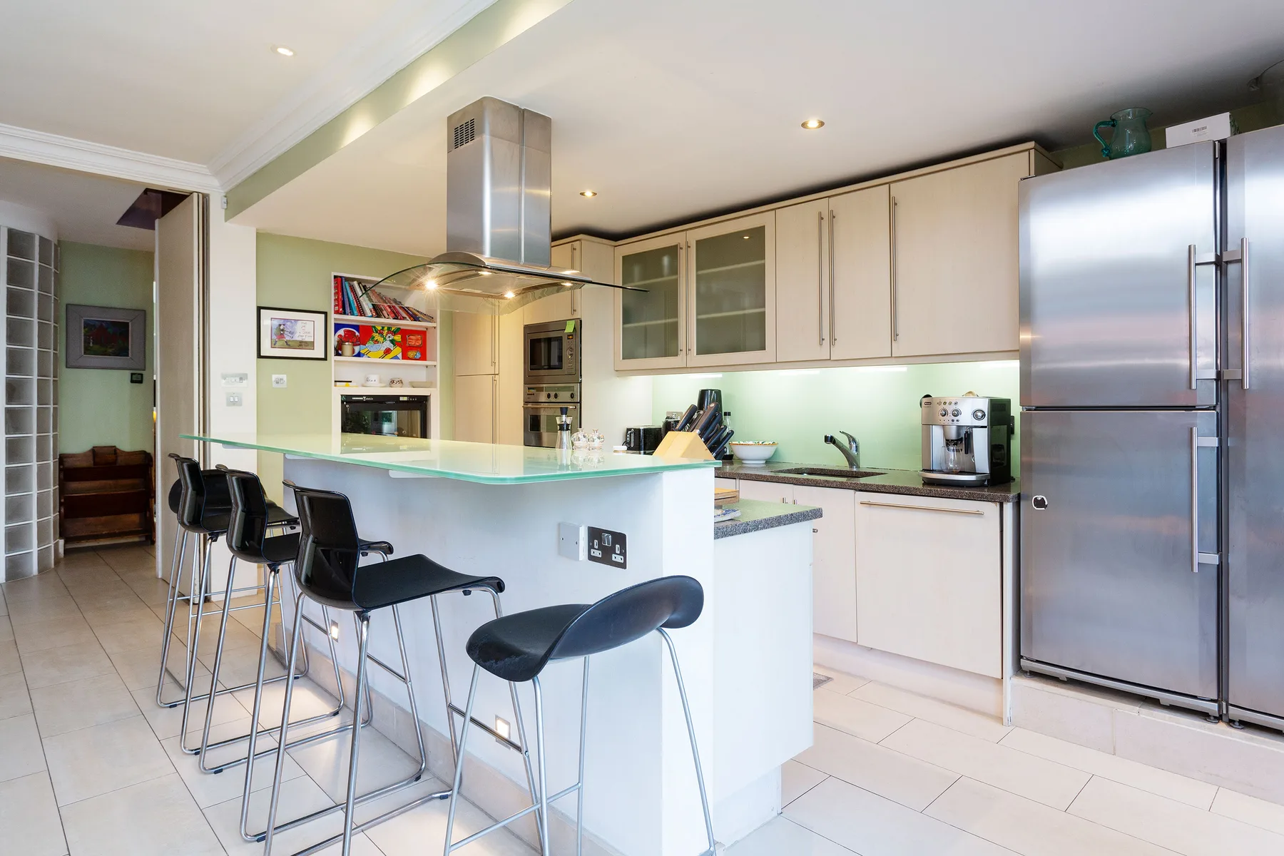 A bright kitchen with a central island and stainless steel appliances.