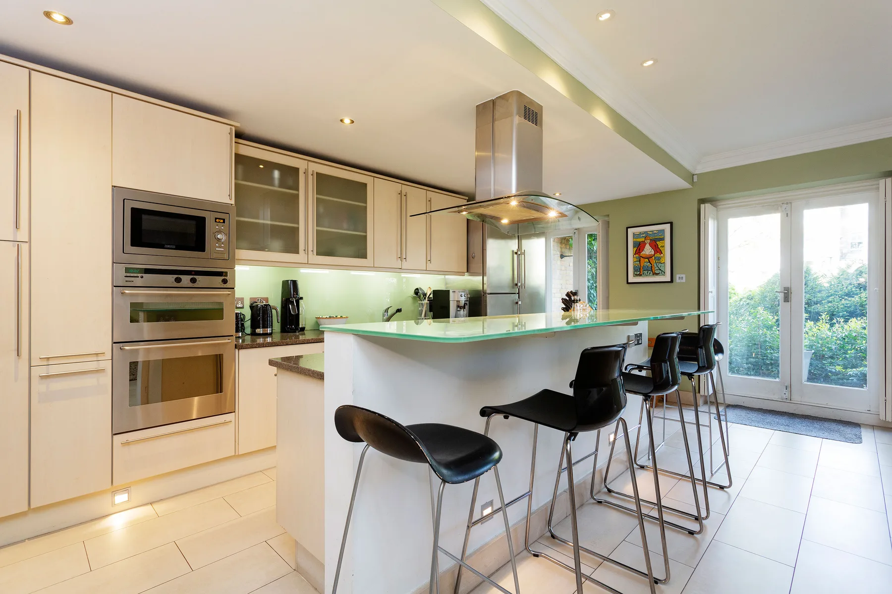 A bright kitchen with a curved breakfast counter and bar seating.