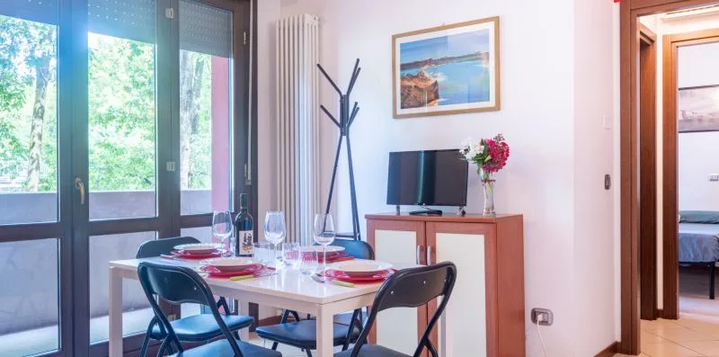 A dining area with a table set beside large glass doors.