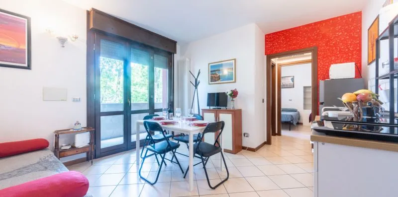 Comedor con una mesa y sillas junto a grandes puertas de cristal.