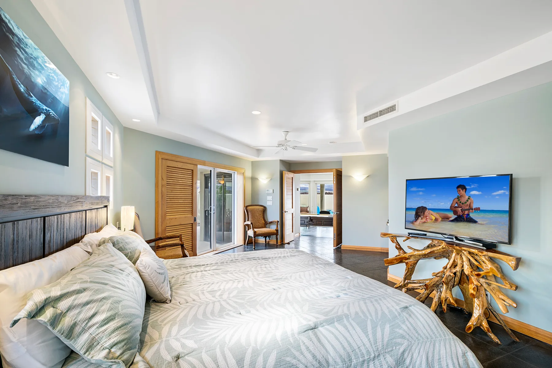 A bedroom with a large bed, windows, and a television.