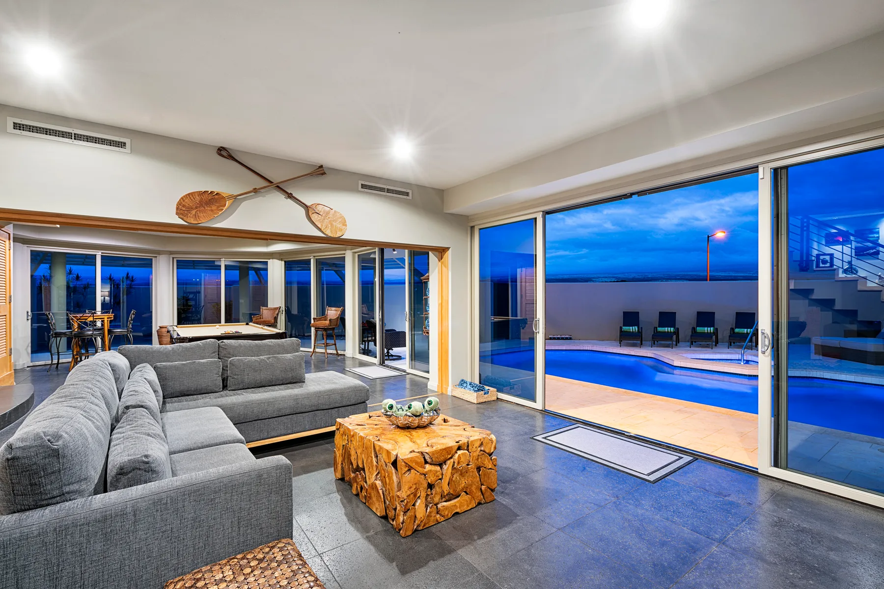 A living room opens onto a patio with a swimming pool.