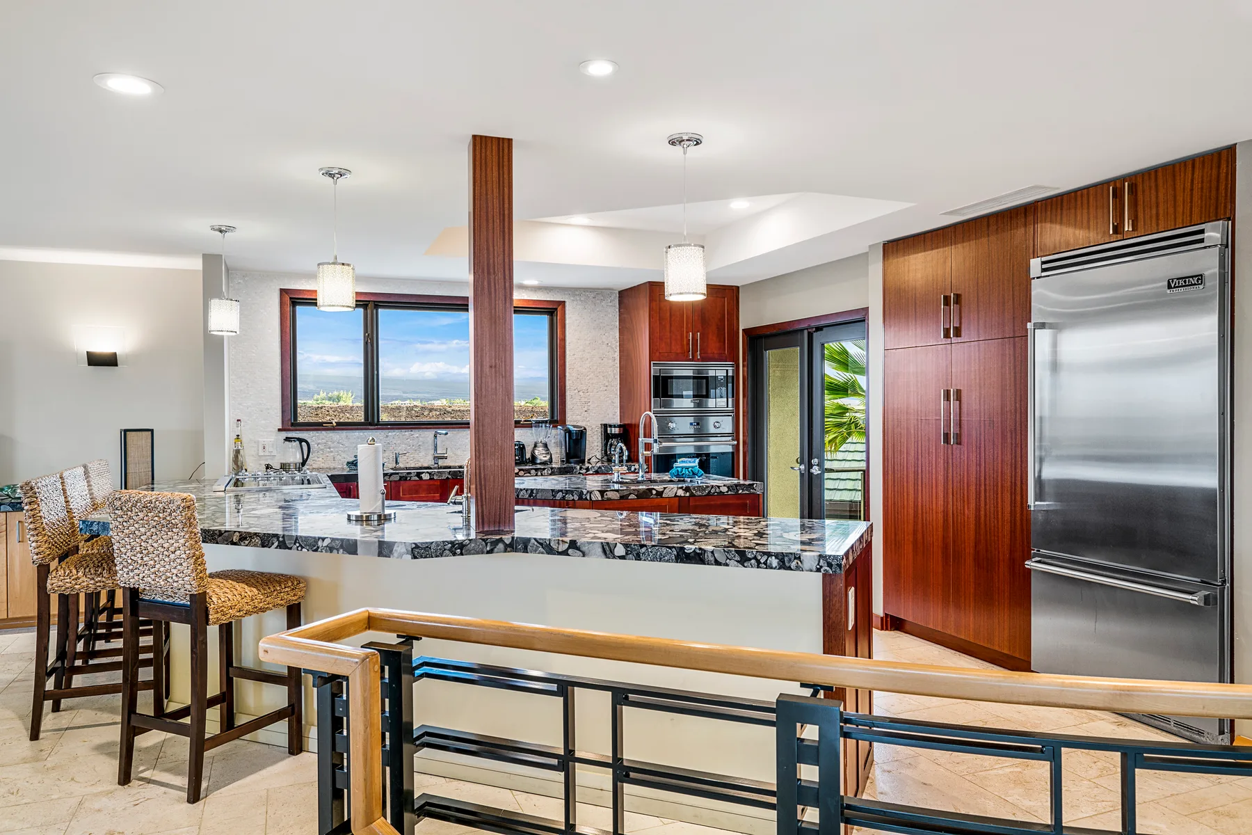 A bright kitchen with a long island and stainless steel appliances.