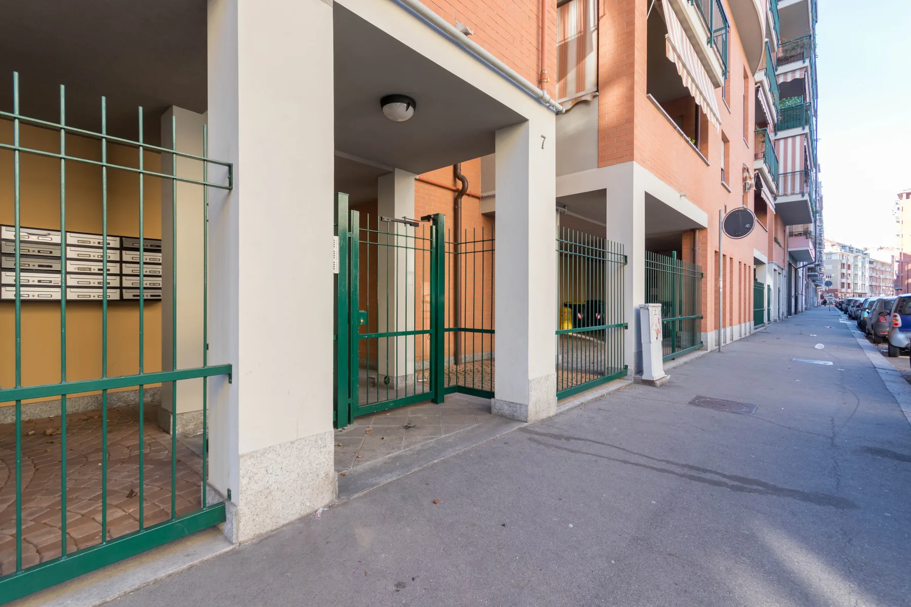 Vista a nivel de calle de las entradas de un edificio de apartamentos junto a la acera.