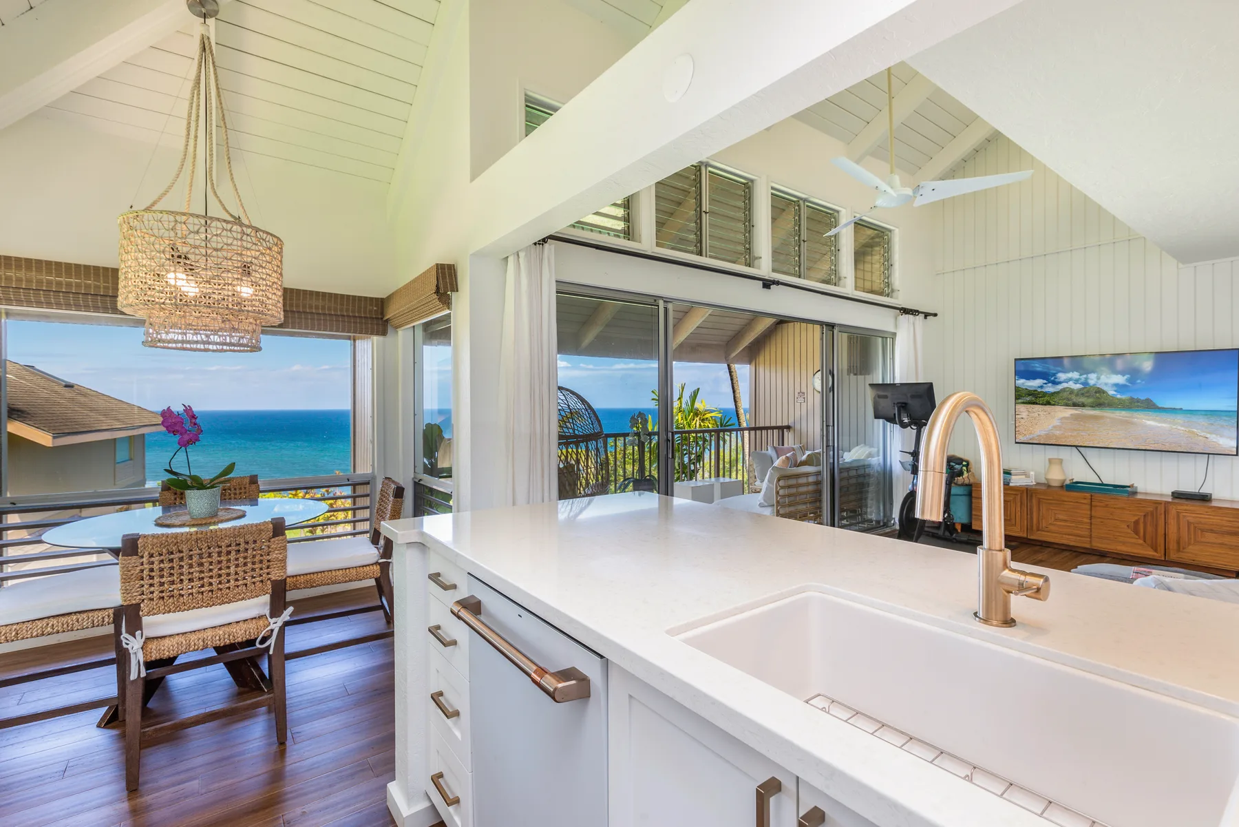 A bright kitchen opens onto a dining area with views of the ocean.