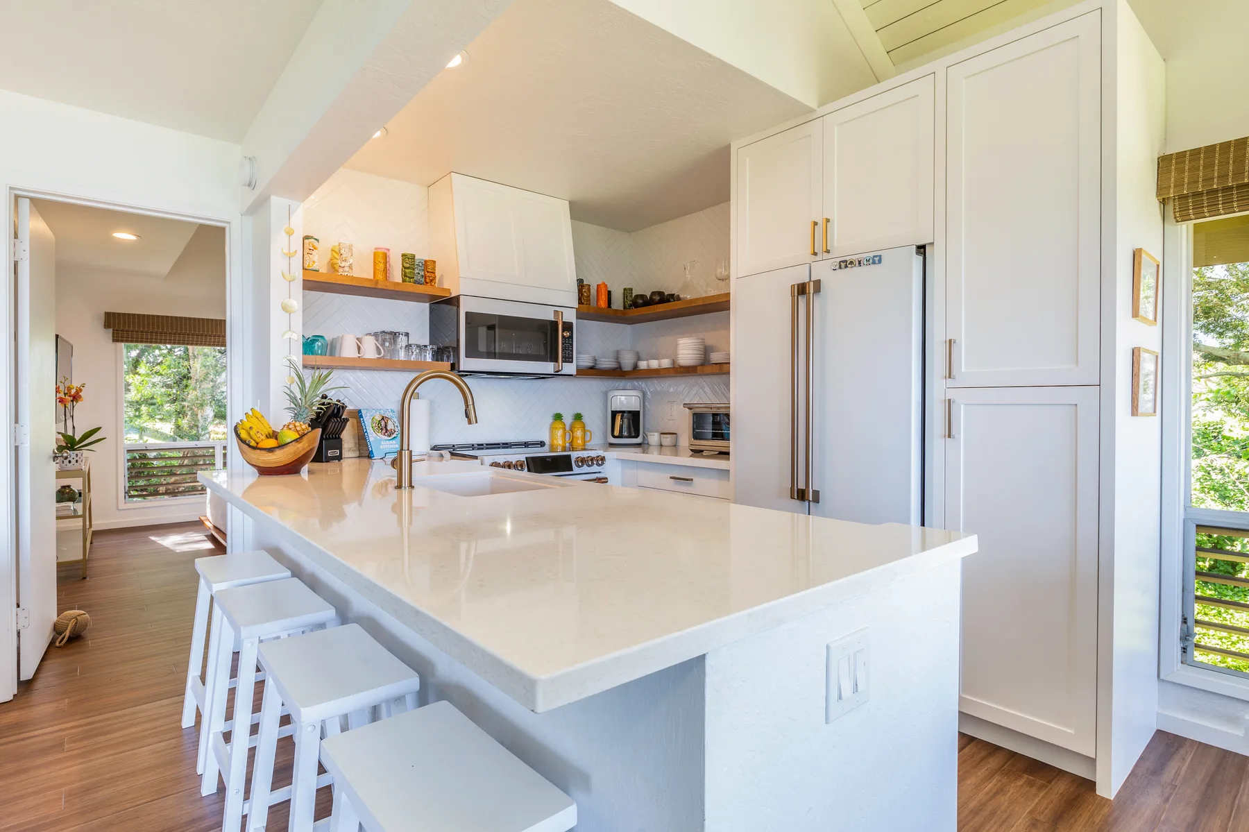 A bright kitchen with white cabinetry, a large island, and bar seating.